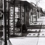Femme attendant le tram 14 à Onex - Salle communale avec un caddie